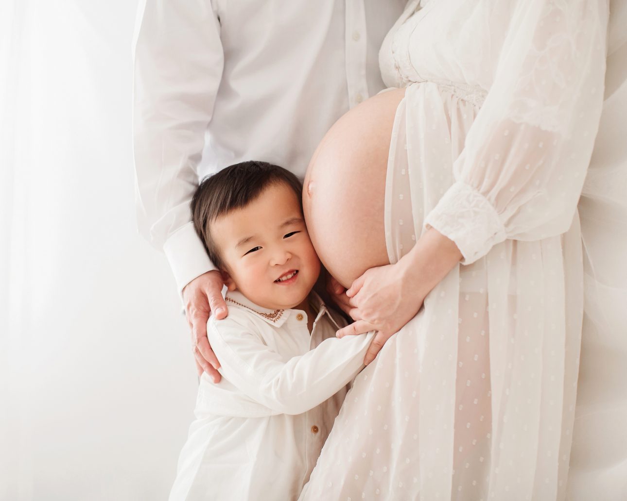 Bromley Maternity Photographer 18 Bromley Pregnancy Photoshoot | photo of a first born son cuddling his mother pregnant bump
